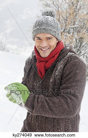 Young man making a snowball View Large Photo Image Stock Photo - Young man making a snowball. Fotosearch