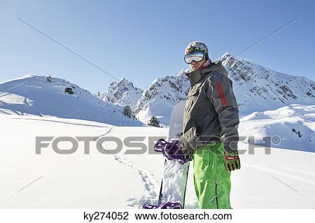 Young man with snowboard in snow View Large Photo Image Stock Image - Young man with snowboard in snow. Fotosearch