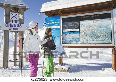 Couple of skiers looking at map, Courchevel, France View Large Photo Image Stock Image - Couple of skiers looking at map, Courchevel, France. Fotosearch