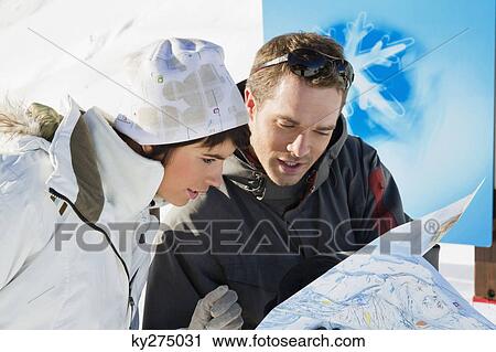 Couple of skiers looking at map, Courchevel, France View Large Photo Image Stock Image - Couple of skiers looking at map, Courchevel, France. Fotosearch