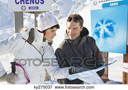 Couple of skiers looking at map, Courchevel, France View Large Photo Image Stock Photo - Couple of skiers looking at map, Courchevel, France. Fotosearch