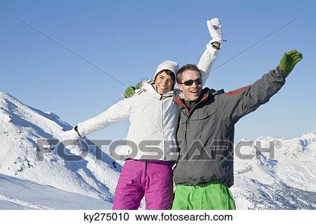 Young couple in ski wear, smiling at camera View Large Photo Image Stock Image - Young couple in ski wear, smiling at camera. Fotosearch