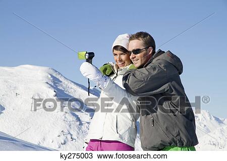 Young couple in ski wear taking self portrait View Large Photo Image Stock Image - Young couple in ski wear taking self portrait. Fotosearch