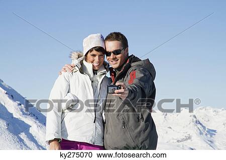 Young couple in ski wear taking self portrait View Large Photo Image Stock Image - Young couple in ski wear taking self portrait. Fotosearch