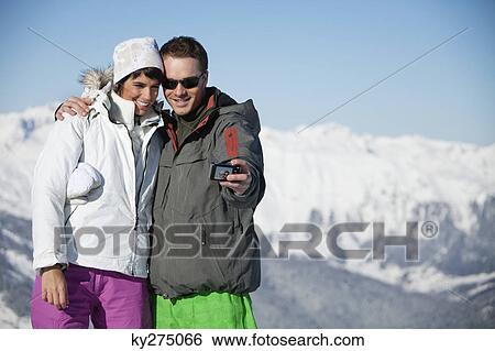 Young couple in ski wear taking self portrait View Large Photo Image Stock Photograph - Young couple in ski wear taking self portrait. Fotosearch