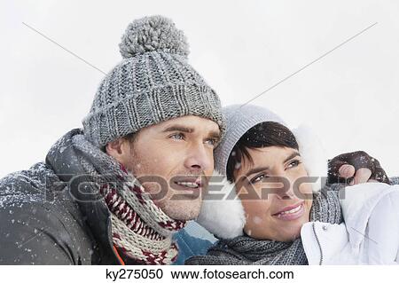 Stock Image - Young couple in winter clothes embracing. Fotosearch