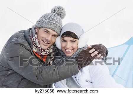 Stock Photo - Young couple in winter clothes embracing. Fotosearch