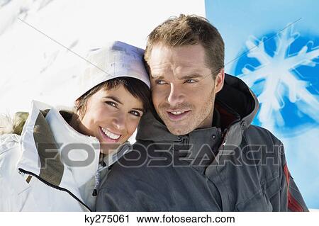 Young couple in winter clothes smiling at camera View Large Photo Image Stock Image - Young couple in winter clothes smiling at camera. Fotosearch
