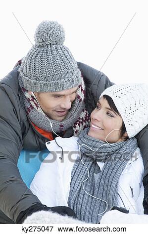 Young couple in winter clothes, listening to music together View Large Photo Image Stock Photo - Young couple in winter clothes, listening to music together. Fotosearch