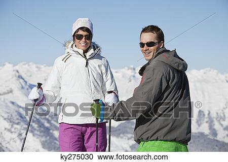 Young couple of skiers smiling at camera View Large Photo Image Stock Image - Young couple of skiers smiling at camera. Fotosearch