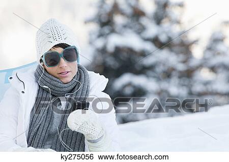 Young woman listening to MP3 player in snow View Large Photo Image Stock Photograph - Young woman listening to MP3 player in snow. Fotosearch