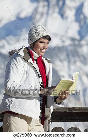 Young woman reading a book, enjoying winter sun, mountains in background View Large Photo Image Stock Image - Young woman reading a book, enjoying winter sun, mountains in background. Fotosearch
