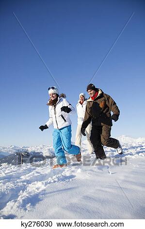Couple and daughter in ski wear running in snow View Large Photo Image Stock Image - Couple and daughter in ski wear running in snow. Fotosearch
