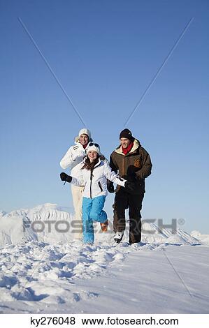 Couple and daughter in ski wear running in snow View Large Photo Image Stock Photo - Couple and daughter in ski wear running in snow. Fotosearch