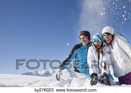 Couple and daughter in ski wear, throwing snow in air View Large Photo Image Stock Image - Couple and daughter in ski wear, throwing snow in air. Fotosearch
