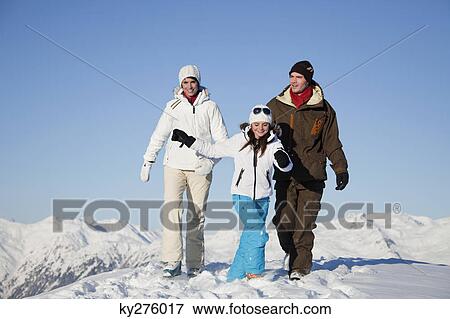 Couple and daughter in ski wear walking in snow View Large Photo Image Stock Photo - Couple and daughter in ski wear walking in snow. Fotosearch