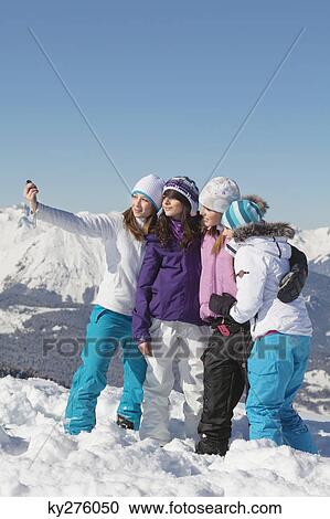 Stock Image - Four teenage girls in ski clothes, taking self portrait. Fotosearch