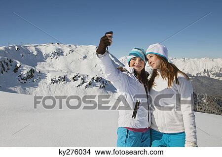 Two teenage girls in ski clothes, taking self portrait View Large Photo Image Picture - Two teenage girls in ski clothes, taking self portrait. Fotosearch