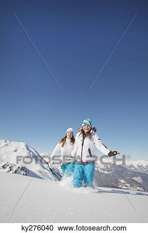 Two teenage girls in ski clothes running in snow View Large Photo Image Stock Image - Two teenage girls in ski clothes running in snow. Fotosearch