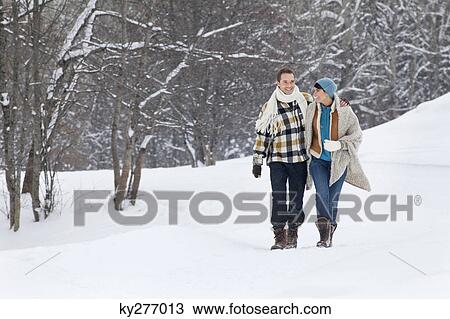 Young couple embracing, walking in snow View Large Photo Image Stock Image - Young couple embracing, walking in snow. Fotosearch