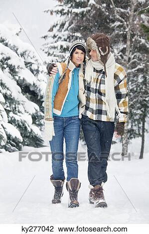 Young couple embracing, walking in snow View Large Photo Image Stock Image - Young couple embracing, walking in snow. Fotosearch