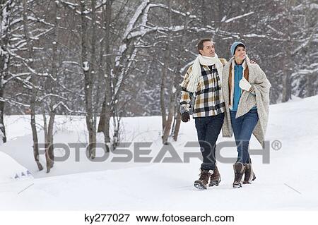 Young couple embracing, walking in snow View Large Photo Image Stock Photo - Young couple embracing, walking in snow. Fotosearch