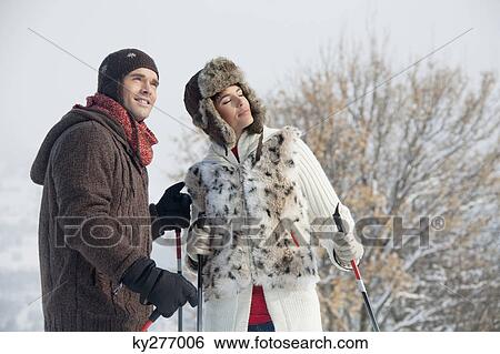 Young couple in winter clothes with ski poles View Large Photo Image Stock Photograph - Young couple in winter clothes with ski poles. Fotosearch