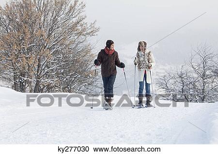 Stock Image - Young couple snowshoeing. Fotosearch