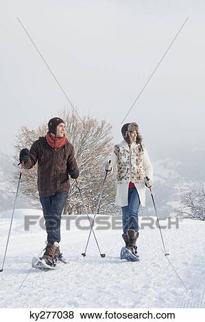 Stock Photo - Young couple snowshoeing. Fotosearch