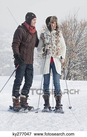Stock Photo - Young couple snowshoeing. Fotosearch