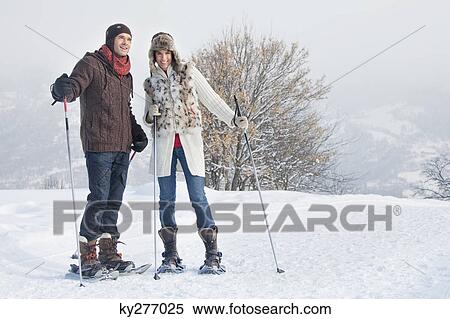 Stock Photography - Young couple snowshoeing. Fotosearch