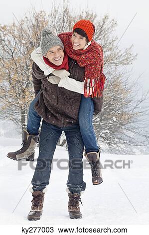 Young man giving his girlfriend piggyback in snow View Large Photo Image Stock Image - Young man giving his girlfriend piggyback in snow. Fotosearch