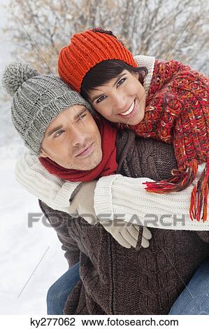 Young man giving his girlfriend piggyback in snow View Large Photo Image Stock Image - Young man giving his girlfriend piggyback in snow. Fotosearch