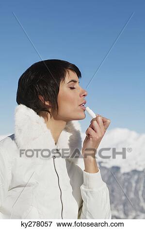 Young woman applying lip balm View Large Photo Image Stock Photo - Young woman applying lip balm. Fotosearch