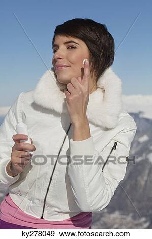 Young woman applying moisturizer View Large Photo Image Stock Photo - Young woman applying moisturizer. Fotosearch