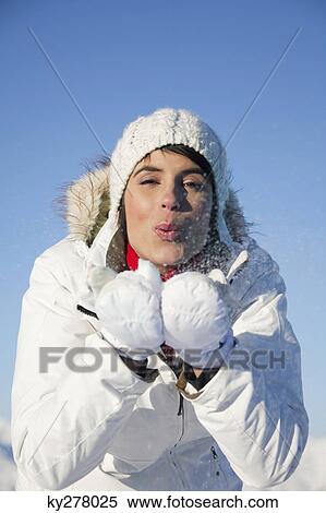 Stock Photography - Young woman blowing snow. Fotosearch