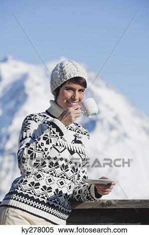 Young woman drinking coffee, mountains in background View Large Photo Image Stock Photography - Young woman drinking coffee, mountains in background. Fotosearch