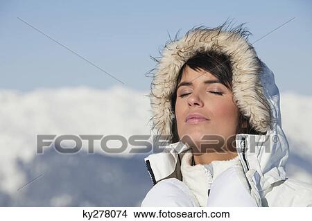 Picture - Young woman enjoying winter sun. Fotosearch