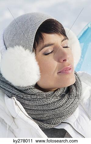 Stock Image - Young woman in winter clothes resting. Fotosearch