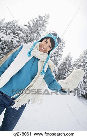 Stock Image - Young woman in winter clothes smiling at camera. Fotosearch