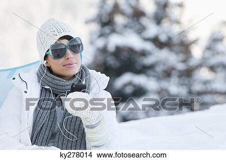 Young woman listening to MP3 player in snow View Large Photo Image Picture - Young woman listening to MP3 player in snow. Fotosearch