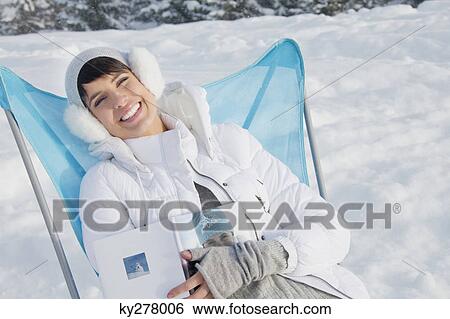 Young woman resting in snow, smiling at camera View Large Photo Image Stock Photograph - Young woman resting in snow, smiling at camera. Fotosearch