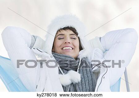 Stock Photo - Young woman resting with hands behind head. Fotosearch