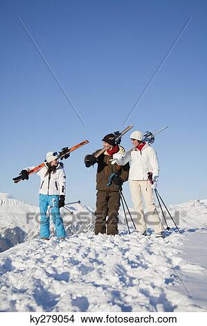 Couple and daughter carrying skis View Large Photo Image Picture - Couple and daughter carrying skis. Fotosearch
