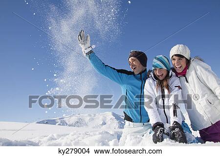 Picture - Couple and daughter in ski wear, throwing snow in air. Fotosearch