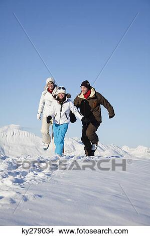 Couple and daughter in ski wear running in snow View Large Photo Image Picture - Couple and daughter in ski wear running in snow. Fotosearch