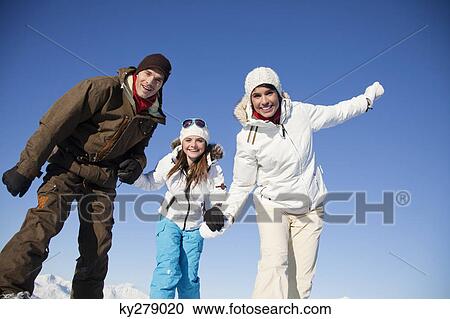 Couple and daughter in ski wear smiling at camera View Large Photo Image Stock Image - Couple and daughter in ski wear smiling at camera. Fotosearch