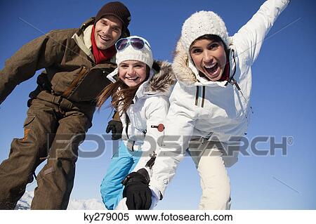 Stock Photography - Couple and daughter in ski wear smiling at camera. Fotosearch