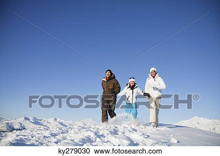 Couple and daughter in ski wear walking in snow View Large Photo Image Stock Image - Couple and daughter in ski wear walking in snow. Fotosearch