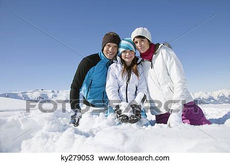 Couple and daughter sitting in snow, smiling at camera View Large Photo Image Stock Image - Couple and daughter sitting in snow, smiling at camera. Fotosearch